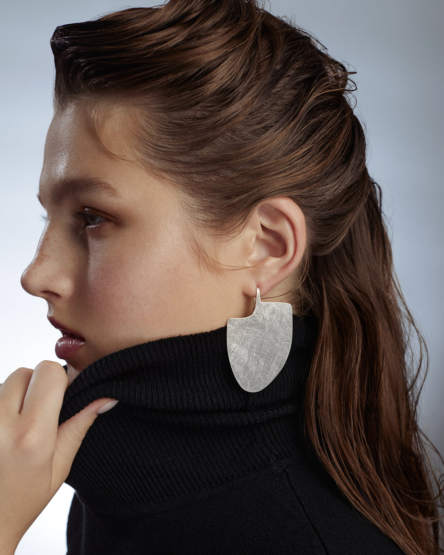 Silver statement earrings on model